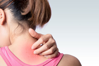 Midsection of woman with pink hair against white background