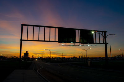 Road by street against sky during sunset in city