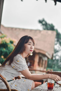 Woman looking away while sitting outdoors