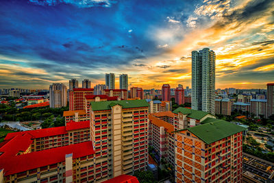 Modern buildings in city against sky during sunset