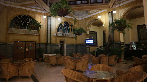 Empty chairs and tables in illuminated building