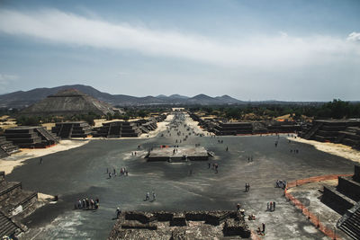 Aerial view of tourists at ancient pyramids against sky