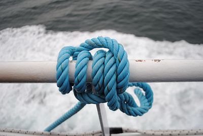 Close-up of rope tied to sailboat in sea