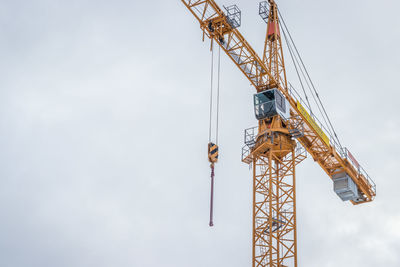 Low angle view of crane against sky