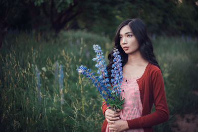 Beautiful woman standing by flowering plants