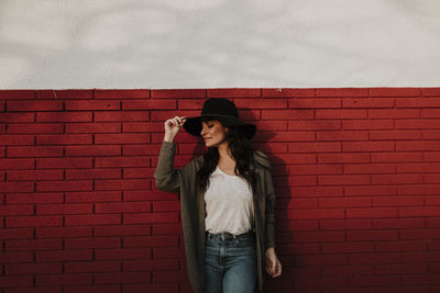 Young woman standing against wall