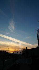 Silhouette buildings against sky at sunset