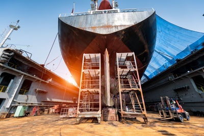 Low angle view of industry against sky during sunset