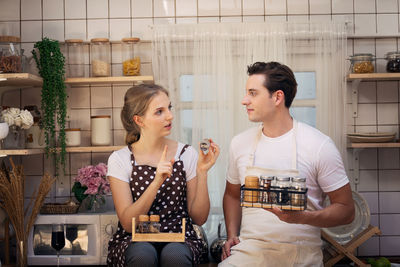 Couple with various spices talking in kitchen at home