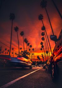 Cars on road against orange sky