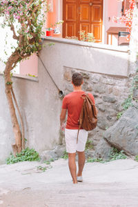 Rear view of man walking by building