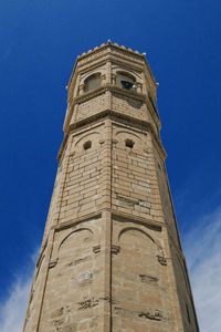 Low angle view of minaret against blue sky