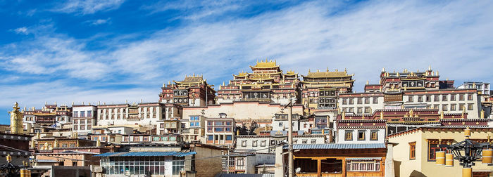 Low angle view of buildings in town against sky