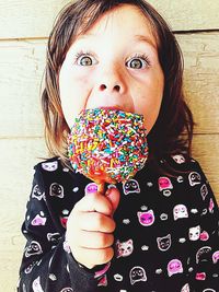 Portrait of cute girl eating candy