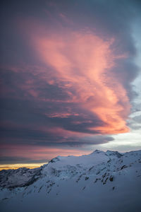 Scenic view of snow covered mountains against sky at sunset