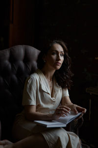 Woman with book sitting on chair