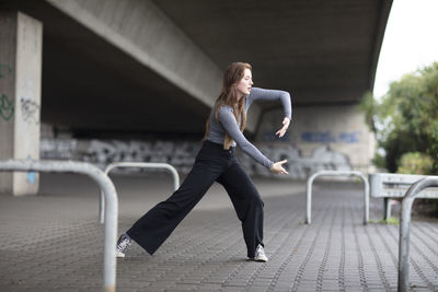 Young woman with dancing on footpath