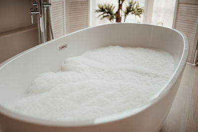 Luxury interior of big bathroom at modern african style with oval bathtub in natural lighting