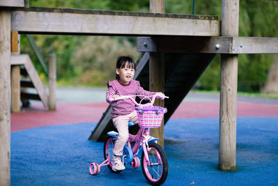 Young  girl ridding bicycle in the summer garden morning