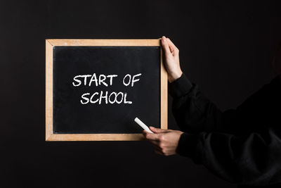 Midsection of man holding blackboard