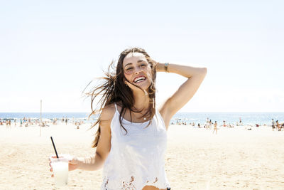 Young woman drinking cocktail on the beach