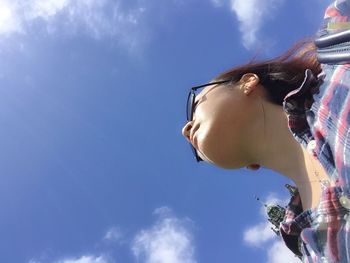 Directly below shot of woman against blue sky