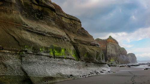 Rock formations by sea against sky