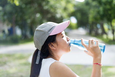 Asian young woman drinking water after jogging,healty and sport concept.