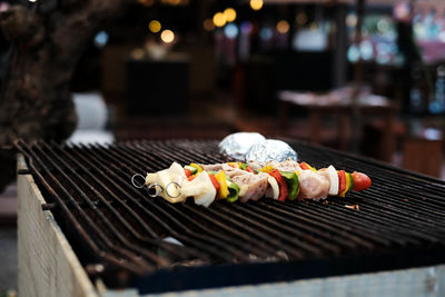 Close-up of meat and vegetables being grilled on barbecue during pool party