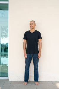 Portrait of young man standing against wall