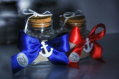 Close-up of anchors and tied bows on containers at table