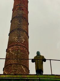 Low angle view of cross on building against sky