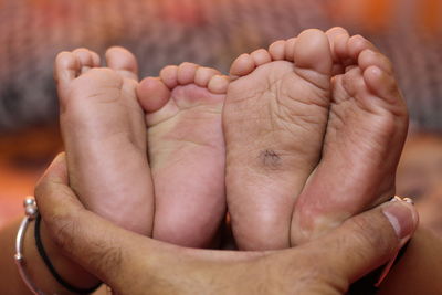 Cropped hand of person holding babies feet