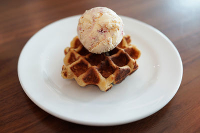 Close-up of ice cream with waffle in plate on table