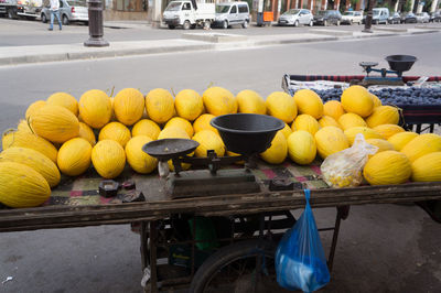 Yellow melons for sale on cart on street