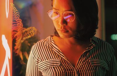 Close-up of woman wearing eyeglasses in nightclub