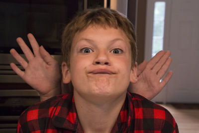Portrait of boy making face at home