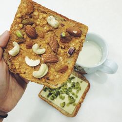 Close-up of hand holding a bread in breakfast