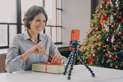 Smiling woman vlogging at home