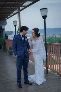 Rear view of couple standing on sidewalk