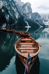 Boat moored on lake against mountains