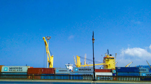 Low angle view of commercial dock against blue sky