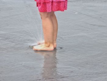 Low section of woman standing in sea