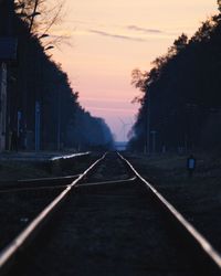 View of railroad tracks against sky at sunset
