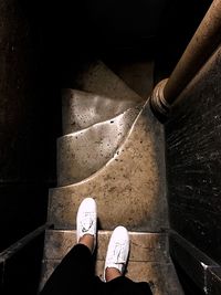 Low section of woman standing on staircase