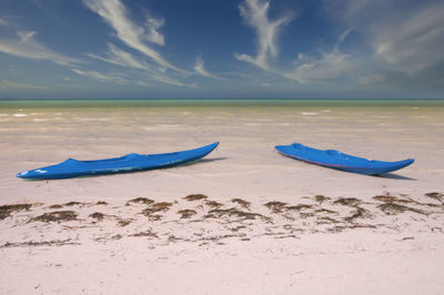 Boat moored on beach against sky