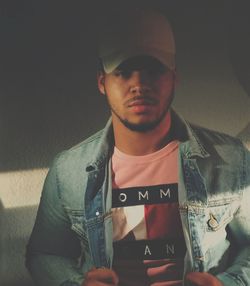 Portrait of young man standing at home