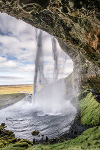 Scenic view of waterfall against sky