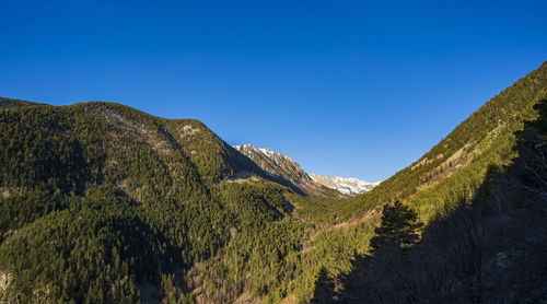 Scenic view of mountains against clear blue sky