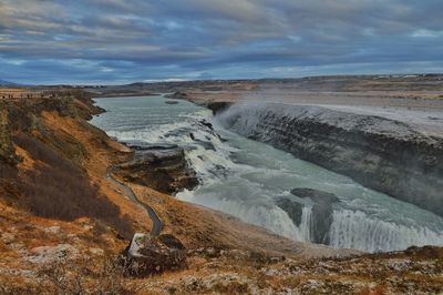 Scenic view of waterfall against sky